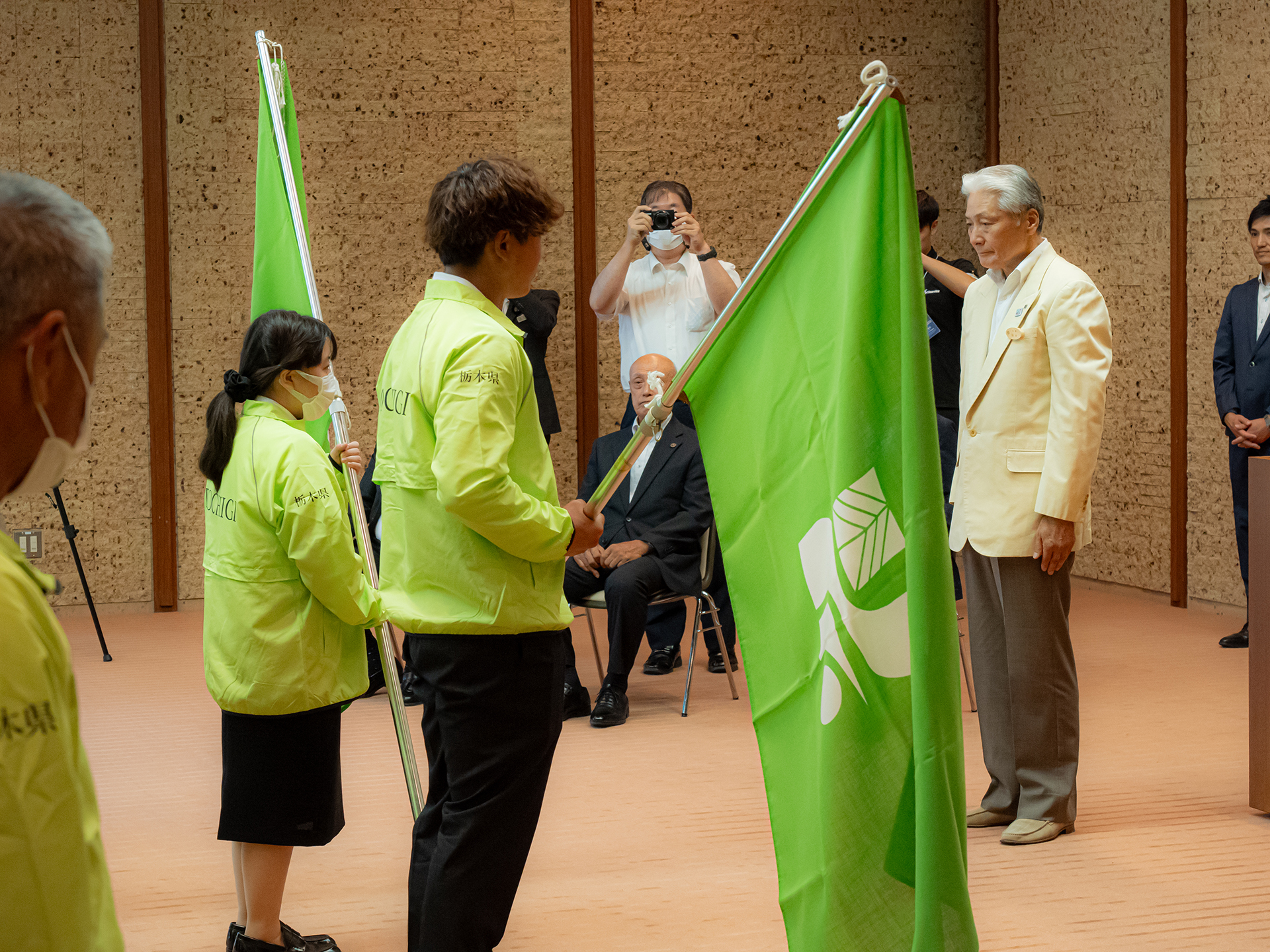 結団式で県知事から県旗を受け取る出場者代表の写真